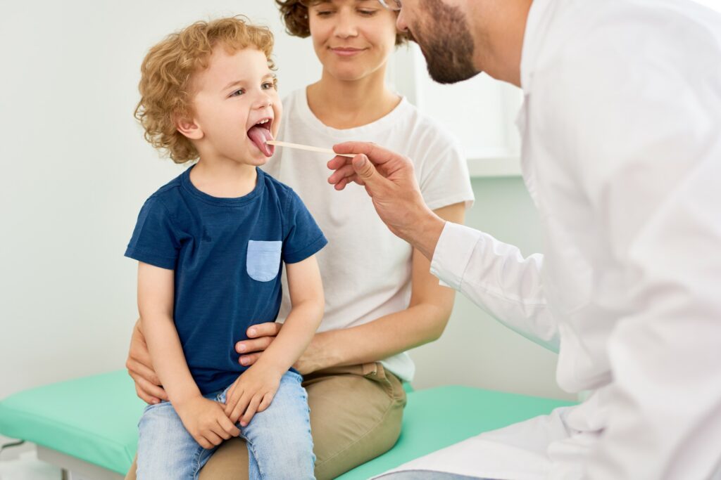 A doctor examines a small child in an exam room.